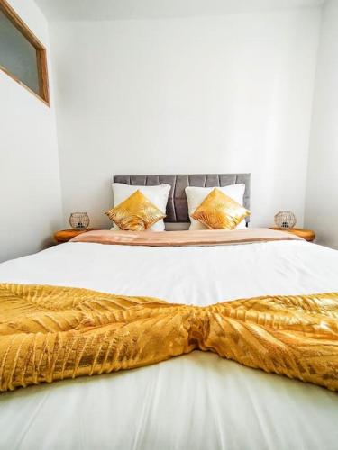 - un lit avec une couverture en or dans l'établissement Les Quais du Centre-Ville, à Romans-sur-Isère