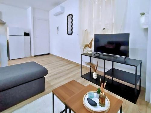 a living room with a couch and a table at Les Quais du Centre-Ville in Romans-sur-Isère