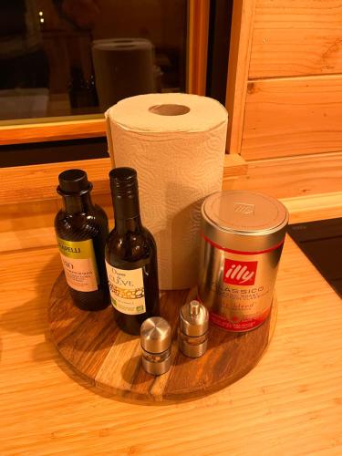 a wooden plate with two bottles of wine and a roll of toilet paper at Heerlijk vertoeven achter de groentetuin in Epe
