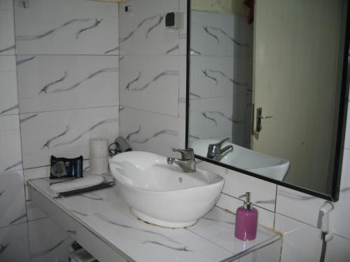 a bathroom with a sink and a mirror at KEUR MARIE FAYE in Mbour