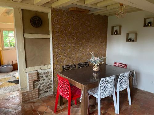 une salle à manger avec une table et quatre chaises dans l'établissement Le Hibou Perché, à Lieurey