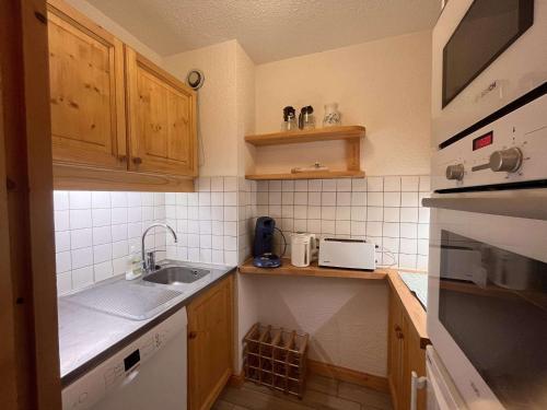 une petite cuisine avec un évier et un comptoir dans l'établissement Appartement cosy, proche commerces et pistes, ideal skieurs, 1 ch, non-fumeur - FR-1-355-247, à Les Allues