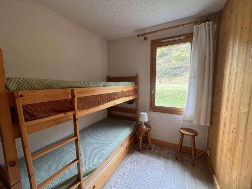 une chambre avec deux lits superposés et une fenêtre dans l'établissement Appartement cosy, proche commerces et pistes, ideal skieurs, 1 ch, non-fumeur - FR-1-355-247, à Les Allues