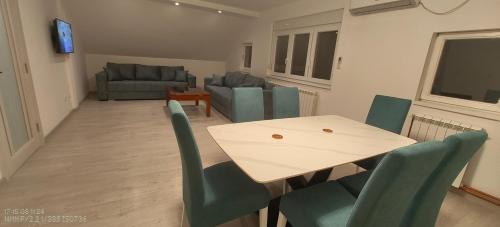 a living room with a table and chairs and a couch at Privatna soba Marijana-Olja in Surčin