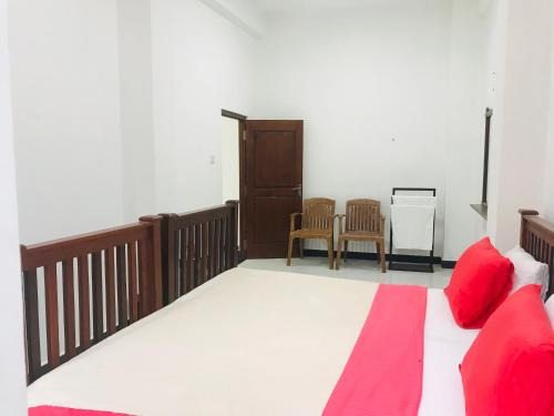 a bedroom with a bed with red pillows and chairs at River Line -Ella in Ella