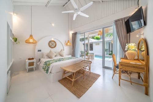 a bedroom with a bed and a table and a piano at The Hepburn Stylish Single Room Guesthouse with Shared Pool 900m from Seminyak Beach in Seminyak