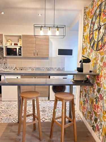a kitchen with a table and two stools at Gîte Ty coz'y in Québriac