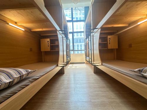 two empty bunk beds in a room with a window at 安家青年寓舍深圳北站店Anjia Youth Hostel Shenzhen Railway North Branch in Lung Wa
