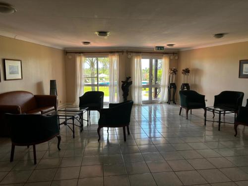 a living room with chairs and a table and a couch at Los Naranjos Termal in Termas del Daymán