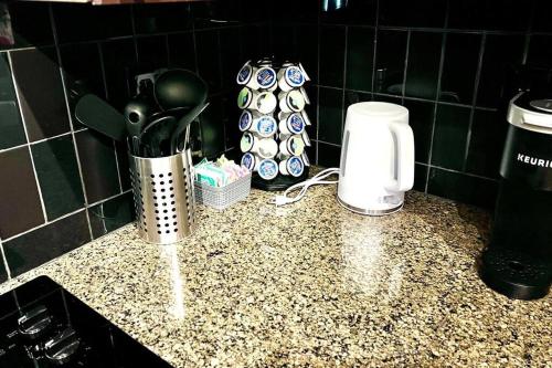 a kitchen counter with utensils and a coffee maker at Beautiful Uptown Adventure Apartment in Charlotte