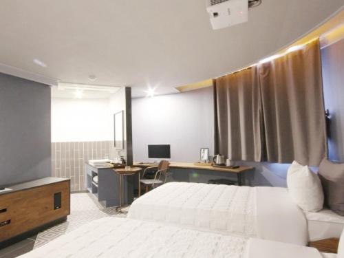 a bedroom with a bed and a desk with a computer at Hotel Browndot Myeongseo Convention in Changwon