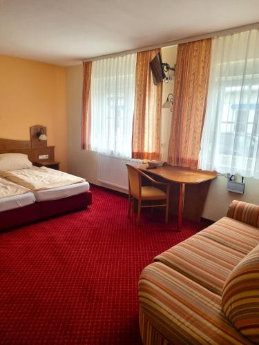a hotel room with two beds and a desk and a table at Zur Turmstube in Dossenheim