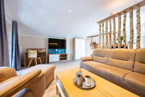 a living room with a couch and a table at Ostsee Apartmenthotel in Graal-Müritz
