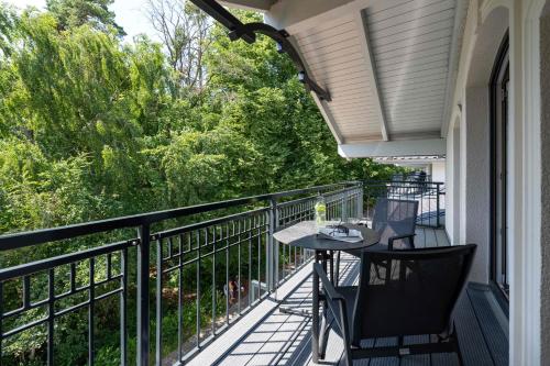 a porch with a table and chairs on a balcony at Ostsee Apartmenthotel in Graal-Müritz