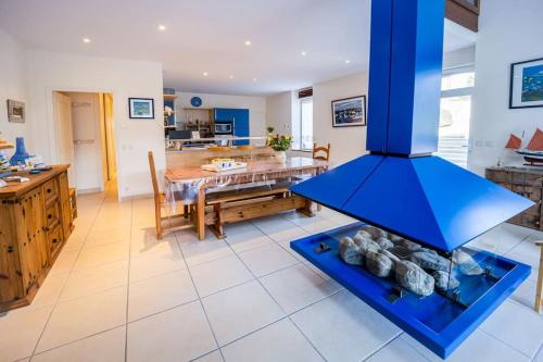 Il comprend une grande cuisine et une salle à manger avec une cuisinière bleue. dans l'établissement Grande longère rénovée spacieuse et lumineuse, à Étel