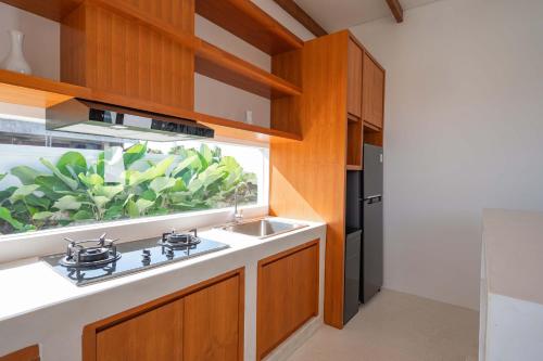 a kitchen with a sink and a window at The Adya Hidden Villa Ubud in Ubud