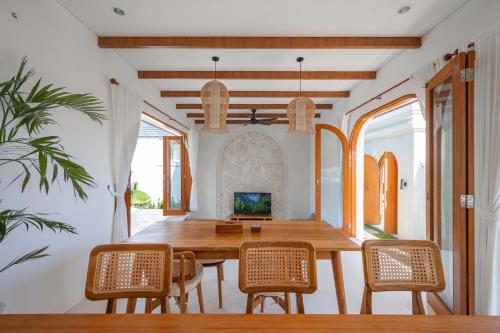 a dining room with a wooden table and chairs at The Adya Hidden Villa Ubud in Ubud