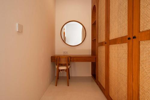 a dressing room with a mirror and a wooden desk at The Adya Hidden Villa Ubud in Ubud