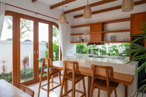 a kitchen with a wooden table and chairs and a fishtank at The Adya Hidden Villa Ubud in Ubud