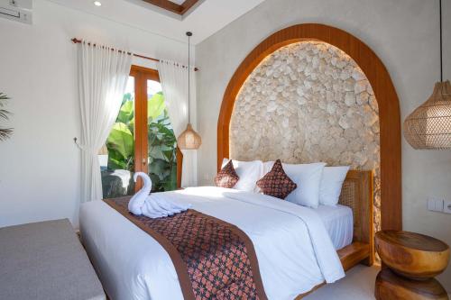 a bedroom with a bed with a swan on it at The Adya Hidden Villa Ubud in Ubud