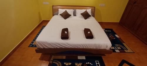 a bed with slippers on it in a bedroom at Zimr in Coonoor