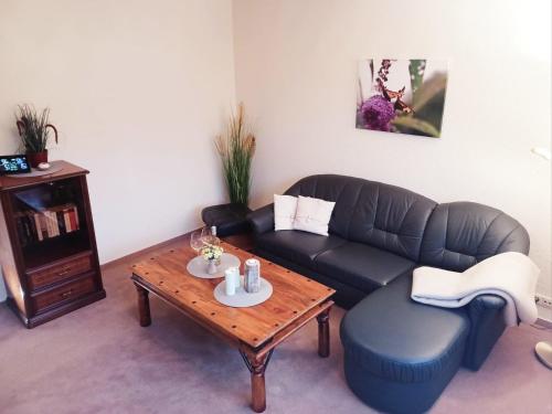 Una sala de estar con un sofá y una mesa de café. en Maisonette Ferienwohnung - Stuth Barth, en Barth