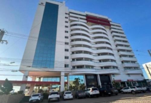 un grand bâtiment avec des voitures garées dans un parking dans l'établissement West Flat Studio30 na Nova Betânia - INNOVA, à Mossoró