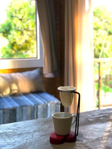 a cup on a table next to a bowl on a table at Jacarecica Haus in Maceió