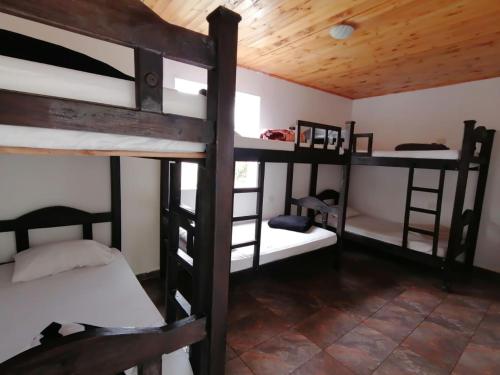a room with four bunk beds in a cabin at Hostal Hilltop Salento in Salento