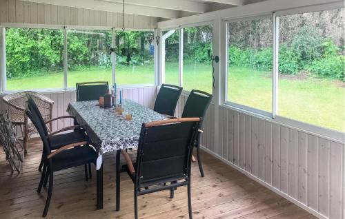 a screened in porch with a table and chairs at 3 Bedroom Lovely Home In Sölvesborg in Sölvesborg
