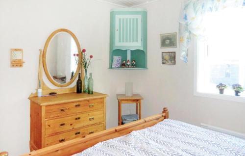 a bedroom with a mirror and a dresser with a bed at 3 Bedroom Lovely Home In Sölvesborg in Sölvesborg