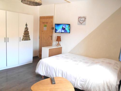 une chambre avec un lit et une télévision au mur dans l'établissement Entre Saint-Tropez et les gorges du Verdon., à Lorgues
