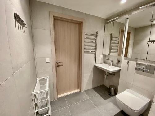 a bathroom with a toilet and a sink and mirror at Vektor Premium Apartment with Rooftop Garden & Free Parking in Tallinn