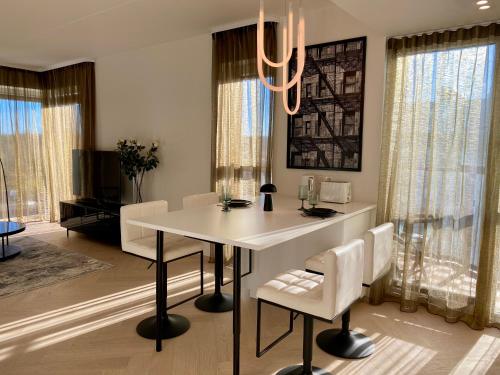a dining room with a white table and chairs at Vektor Premium Apartment with Rooftop Garden & Free Parking in Tallinn