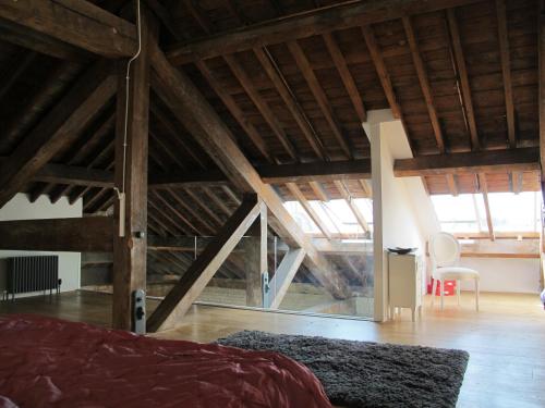 an attic room with a bed and a chair at 45 Brewhouse - Royal William Yard in Plymouth