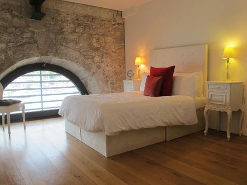 a bedroom with a large bed and a brick wall at 45 Brewhouse - Royal William Yard in Plymouth