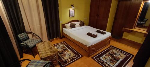 a small bedroom with a bed and a chair at Zimr in Coonoor