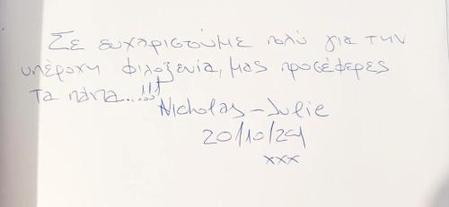 a letter written in cursive handwriting on a white paper at Intimate Olympus House in Litochoro