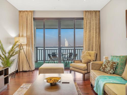 a living room with a couch and a table at Luxury Apartments in Anantara Resort with Stunning Burj AlArab & Sea Views in Dubai