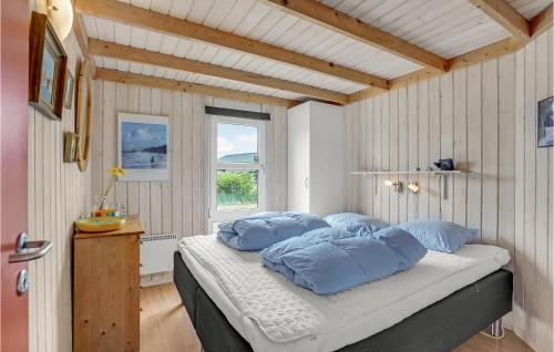 a bedroom with a bed with blue pillows and a window at Lovely Home In Hjørring With Wifi in Hjørring