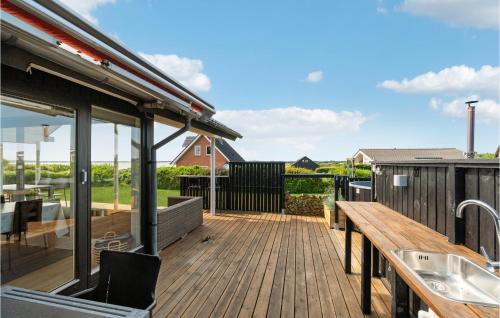 a deck with a bench and a sink on a house at Awesome Home In Øster Assels With Sauna in Øster Assels