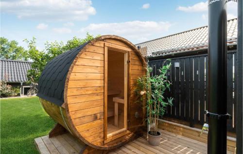 a wooden barrel with a window on a deck at Awesome Home In Øster Assels With Sauna in Øster Assels