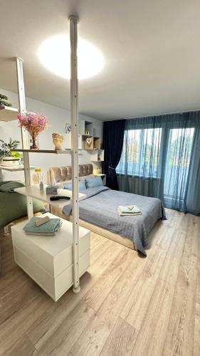 a bedroom with a large bed and a wooden floor at LIUxSAU apartmentai in Mažeikiai