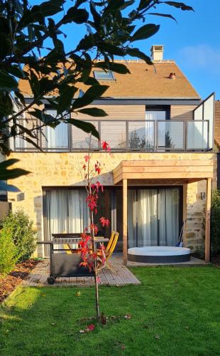 une maison avec une table et un banc dans la cour dans l'établissement Natural Design Lodge Jacuzzi Privatif, à Milly-la-Forêt