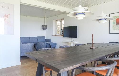 a dining room with a wooden table and chairs at Stunning Home In Nexø With Kitchen in Neksø