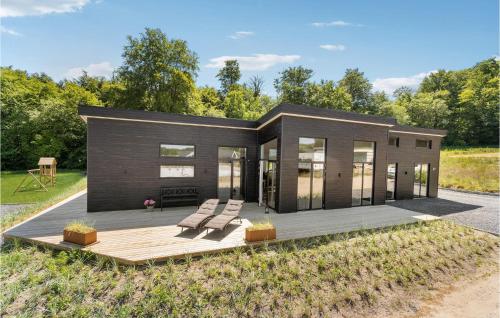 Casa modular con terraza de madera y bancos en Nice Home In Sjølund With Sauna, en Sjølund