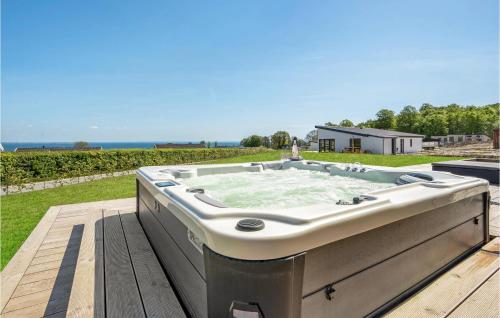 a large bath tub sitting on a deck at 3 Bedroom Nice Home In Sjølund in Sjølund