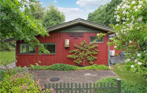 a red house with a fence in front of it at Amazing Home In Ansager With Lake View in Ansager