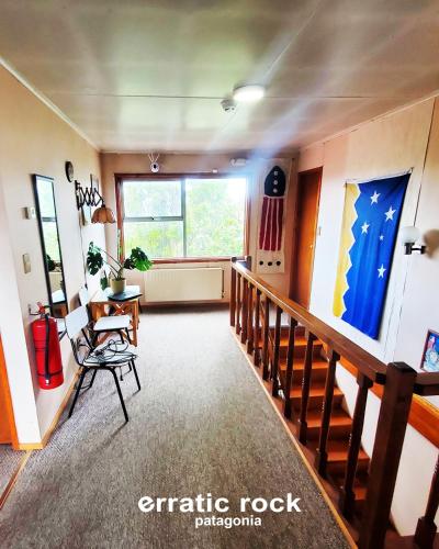a living room with a staircase and a large window at erratic rock in Puerto Natales