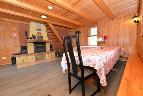 a dining room with a table with a vase of flowers on it at Anykščių raj. Žalioji Stotelė in Šventupys